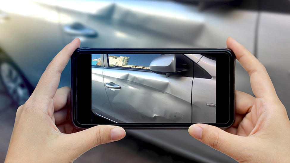 Taking a photo of damage to a car after an accident.