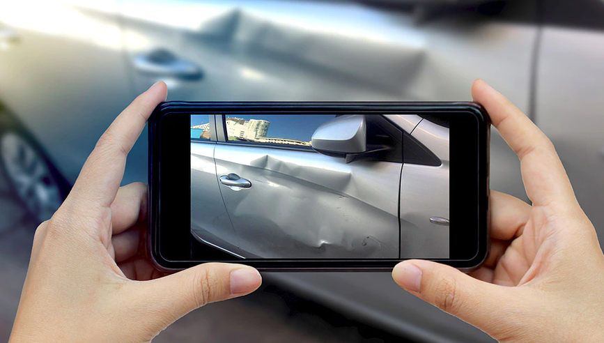 Taking a photo of damage to a car after an accident.