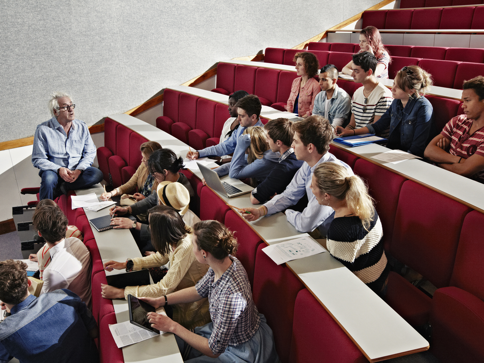 Students listening to a teacher in a lecture hall.