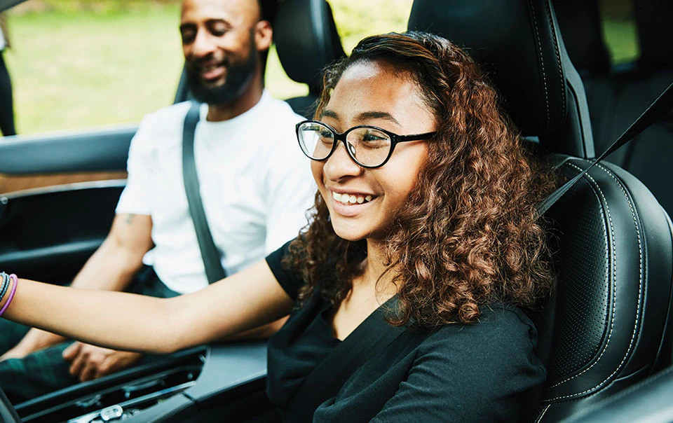 Teenager driving a car accompanied by a parent.