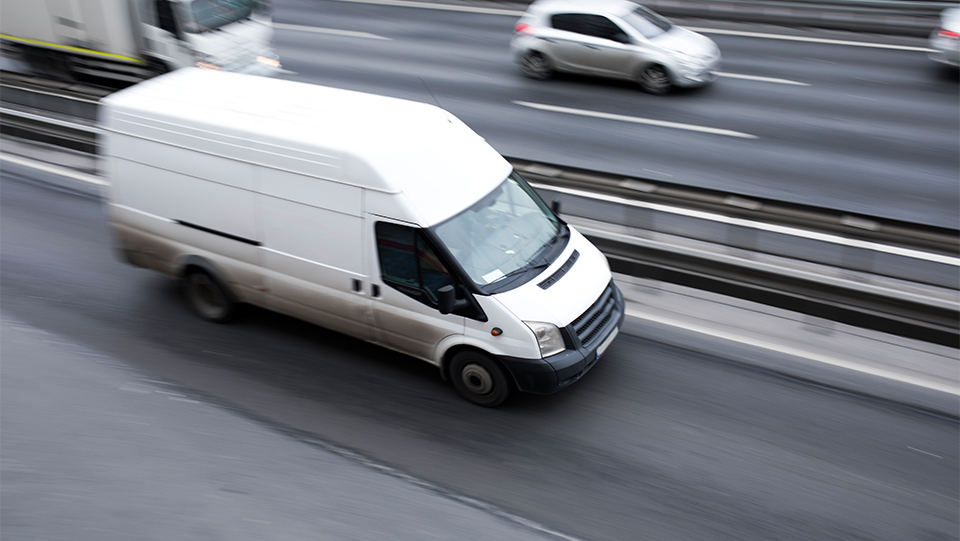 Commercial van driving down a highway.