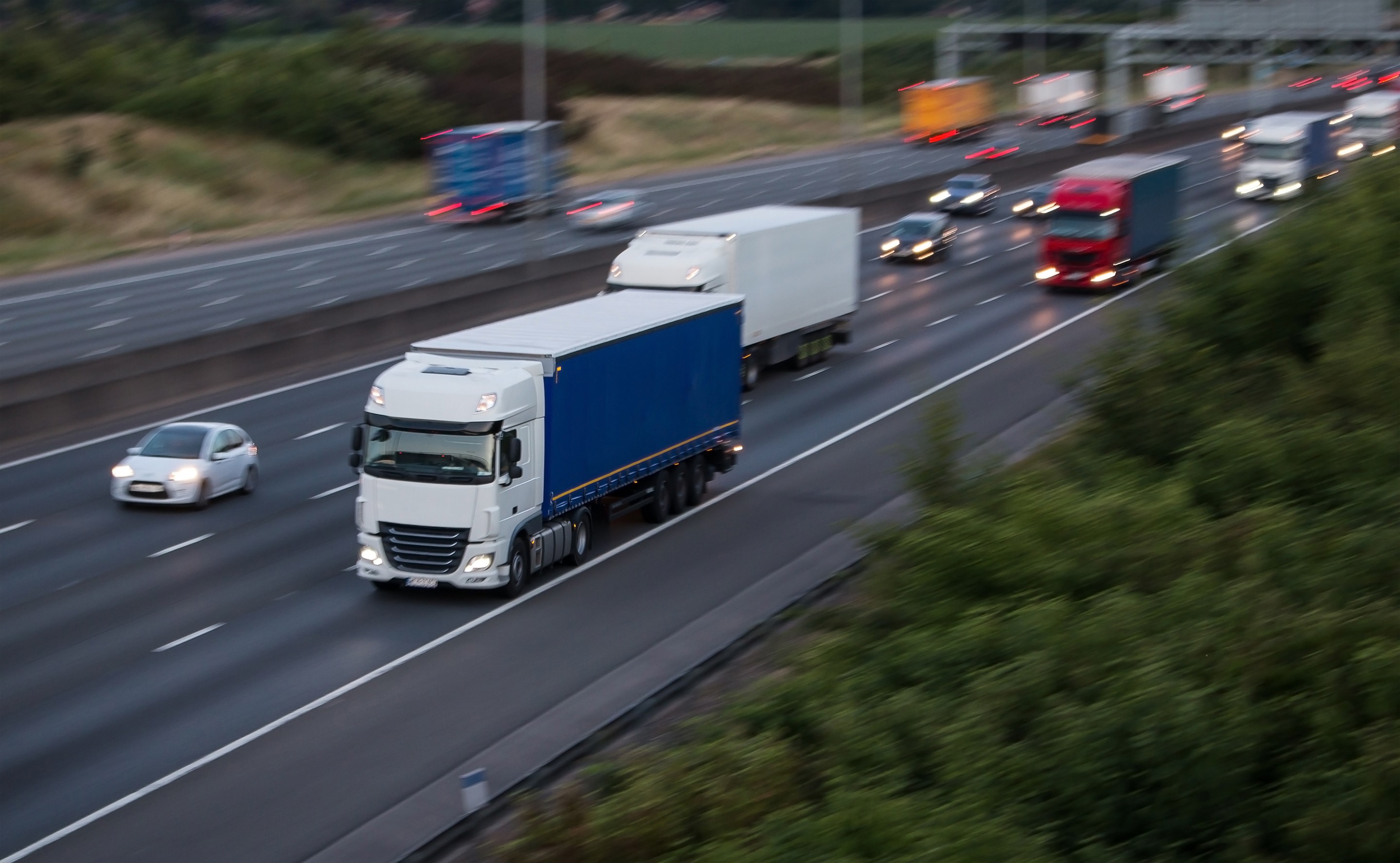 Trucks on the motorway alongside smaller cars.