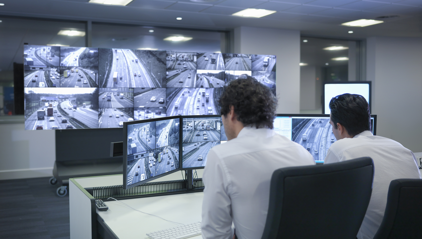 Managers monitoring fleet drivers on tracking system on screen.