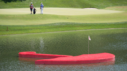 floating red umbrella in middle of Travelers Championship course