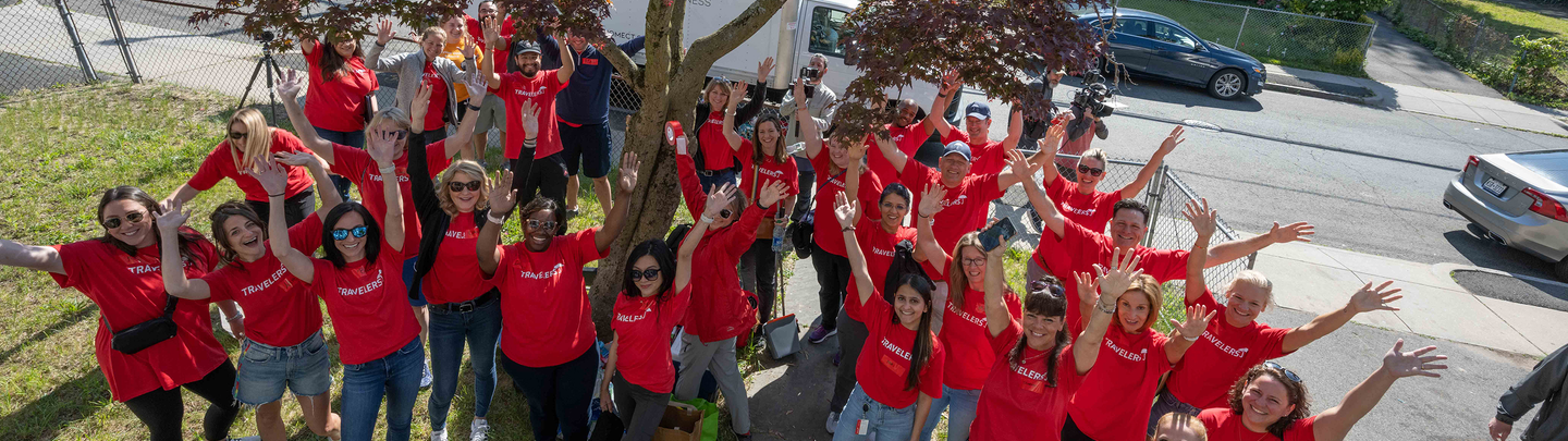 A group of Travelers volunteers smile while serving the community.