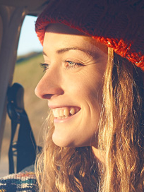 Carefree woman smiles while on a road trip.