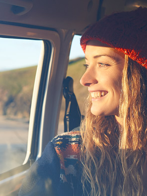 Woman with a carefree smile riding on an open road.