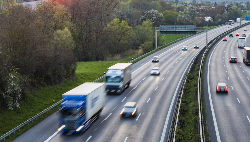 Trucks and cars driving down a freeway.