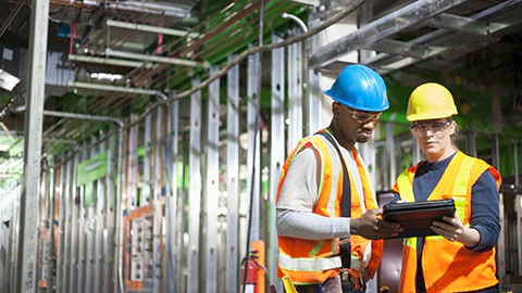 Two construction workers reviewing safety process.