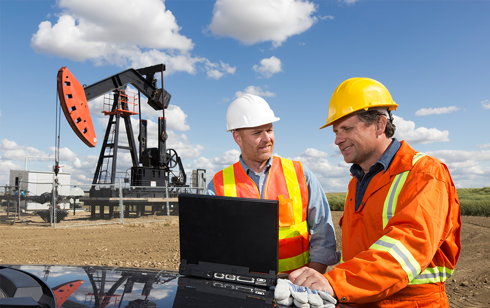 Two oil workers on laptop welcome.