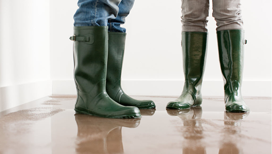Two people standing in a flooded room.