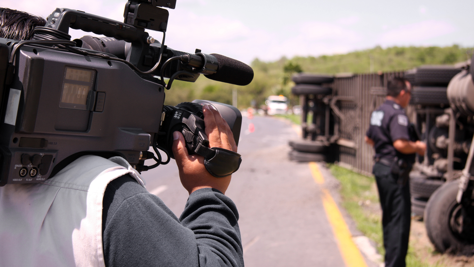 reporter with camera viewing accident