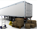 View of the back of a white trailer with brown boxes beside its wheels