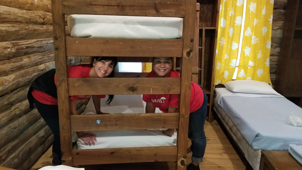 Travelers employees volunteering at Hole in the Wall Gang Camp, making the bed.