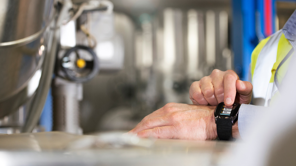 Person pressing a button on a wearable device around their wrist.