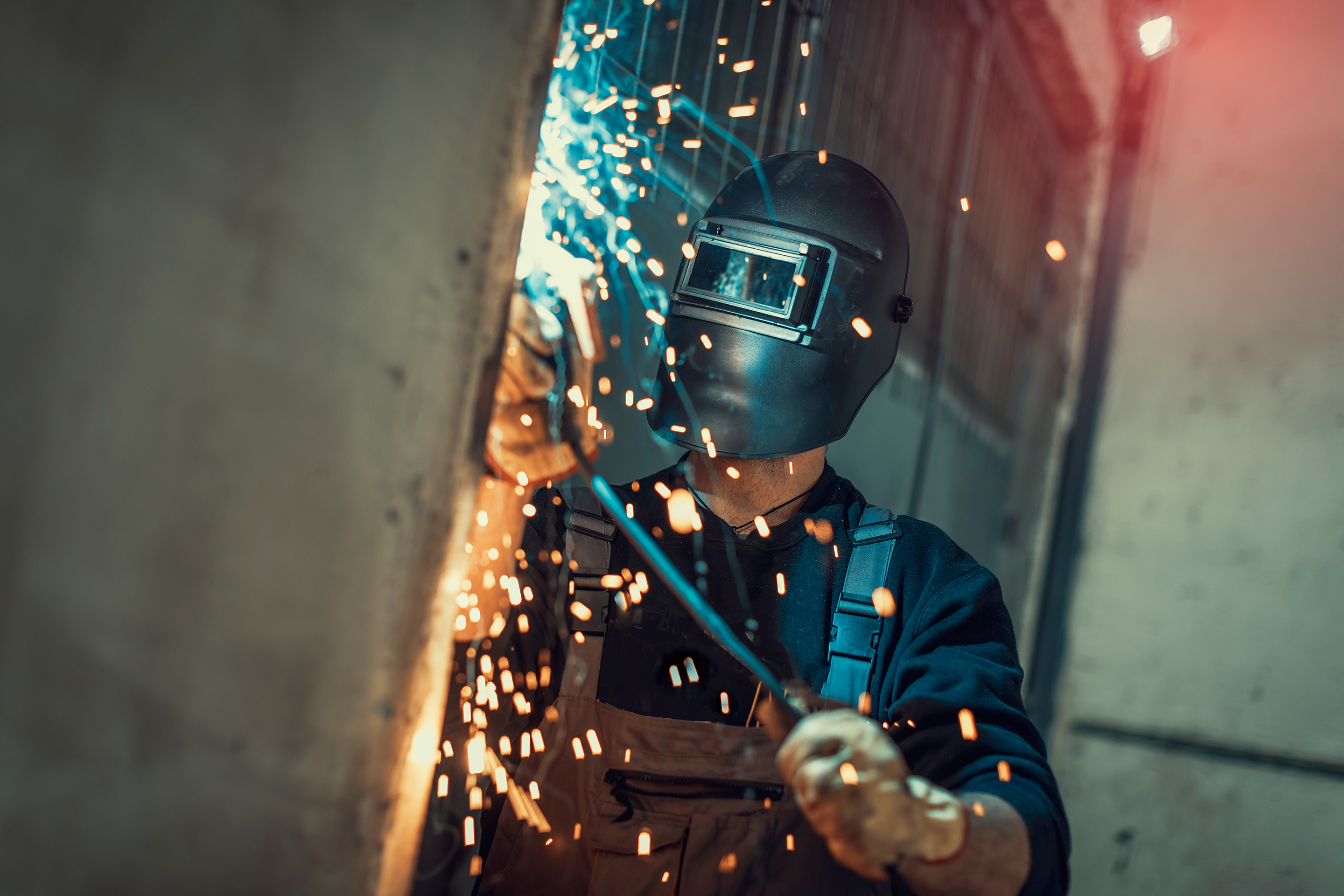 An employee grinding steel with sparks.