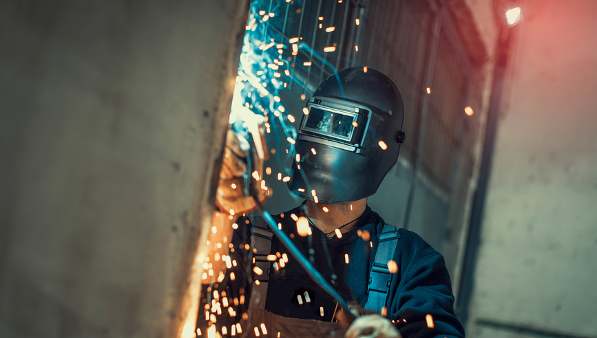 An employee grinding steel with sparks.