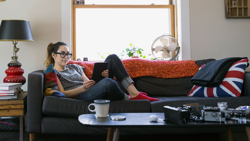 Woman laying on couch in apartment.