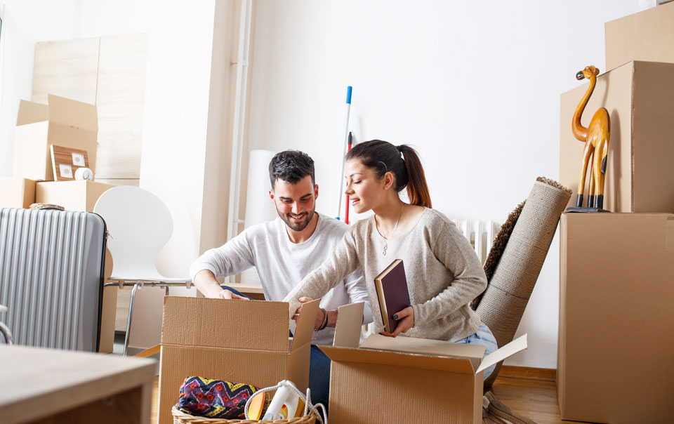 Couple of renters unpacking boxes in apartment.