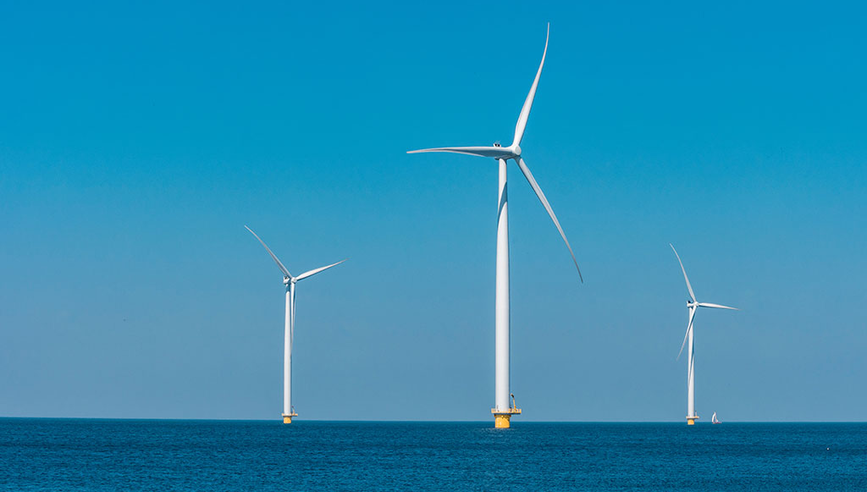 Wind farm shown out in the ocean.