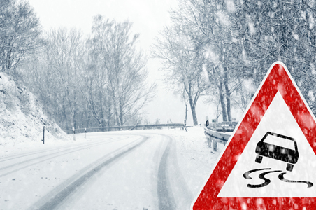 Winding road with snow and ice and red hazard sign