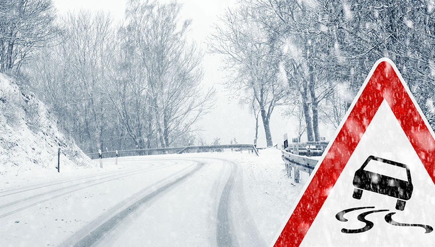 Winding road sign on a snowy road