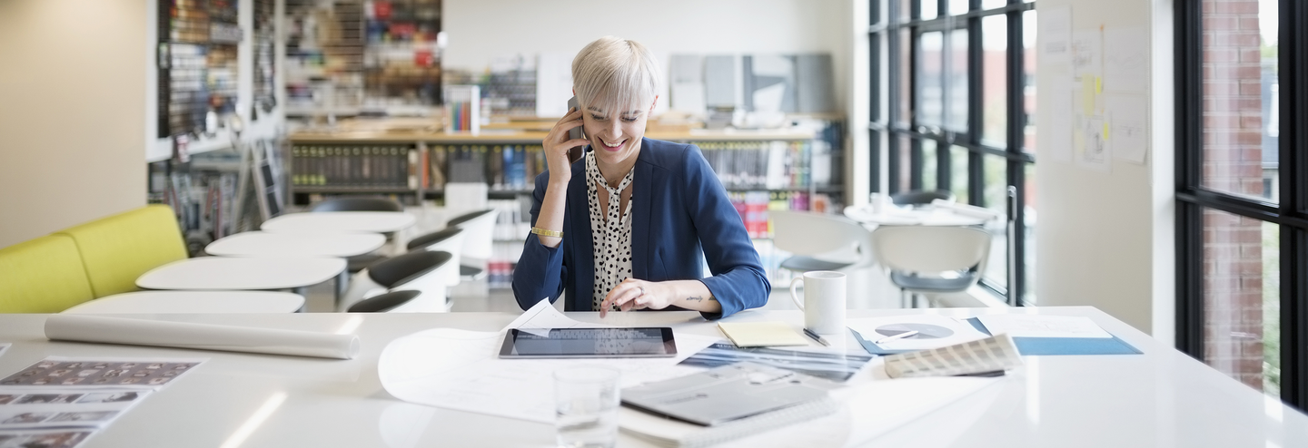 A woman talks on a cellphone in a business office.