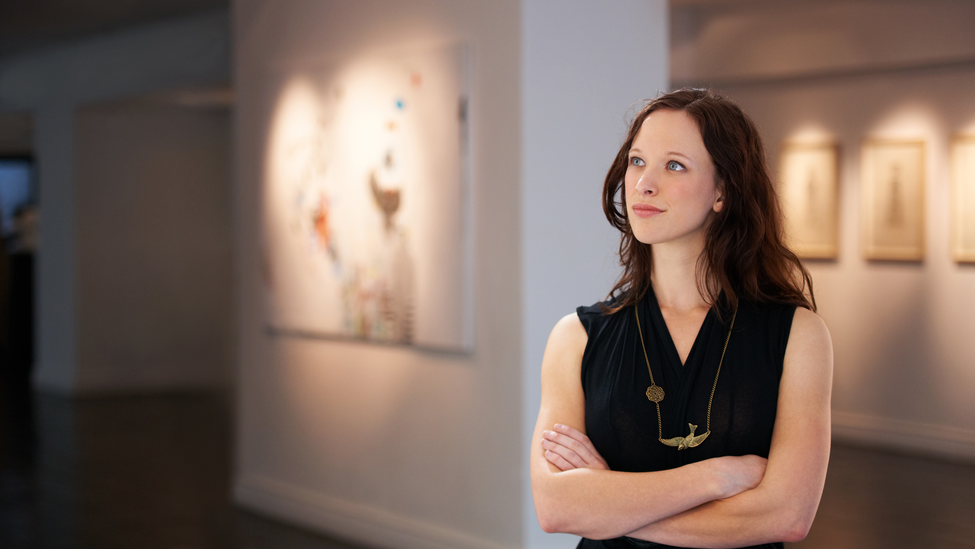 A woman looking at wall art in a museum.