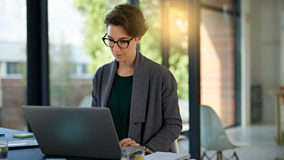 Business woman tackling deadlines on her laptop in an office