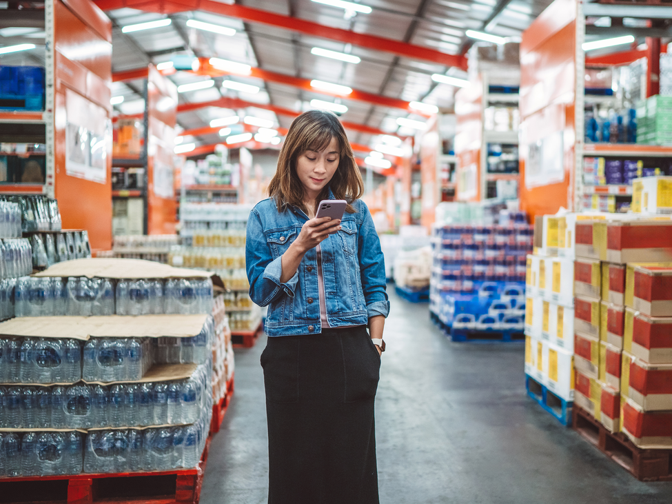 Woman looking at her phone in a warehouse.