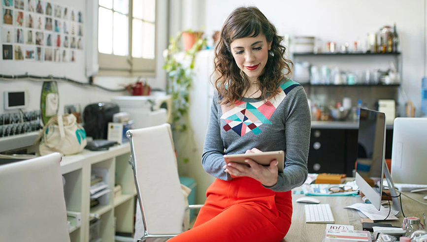 Woman in apron using cell phone.