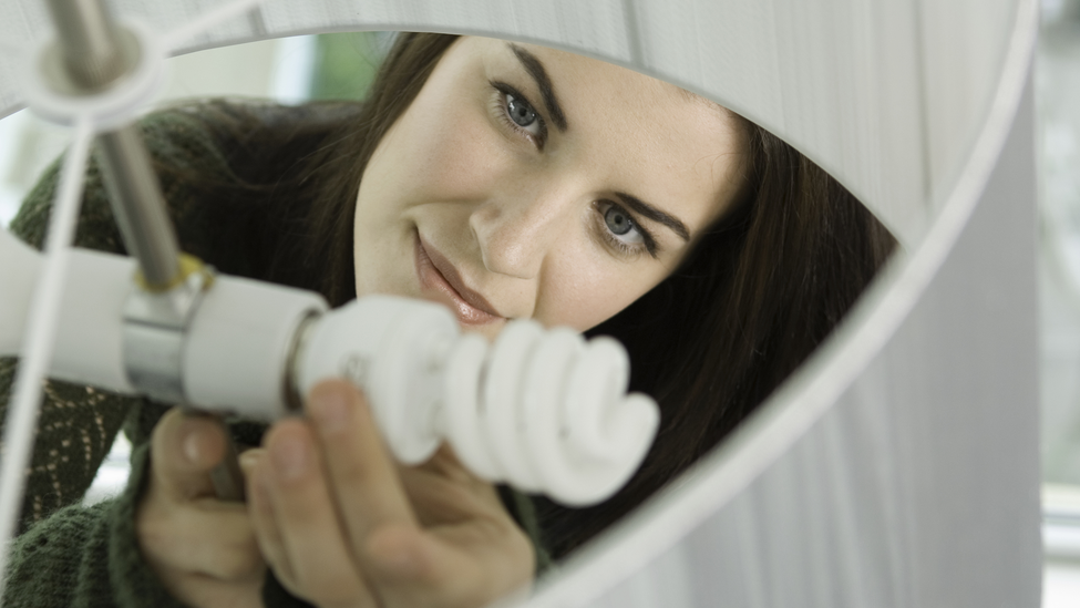 Person installing energy efficient light built in home.