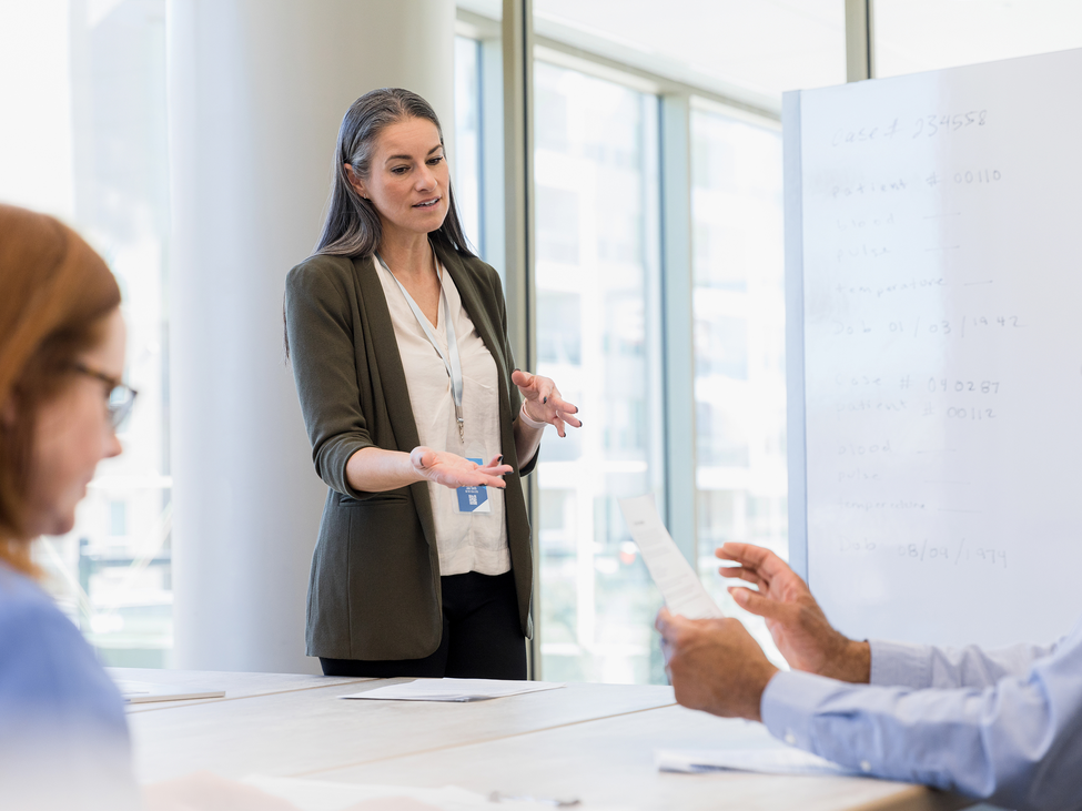 Executives discuss management decisions in a modern office setting.