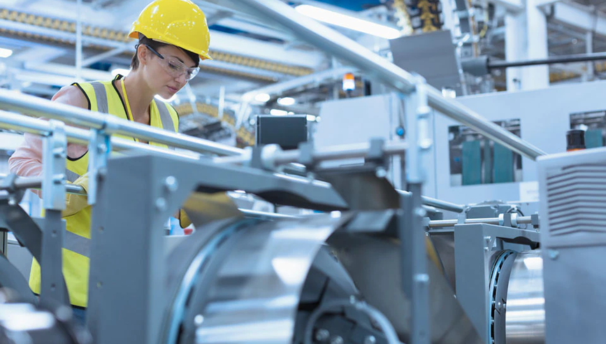 Woman looking at equipment in manufacturing plant.