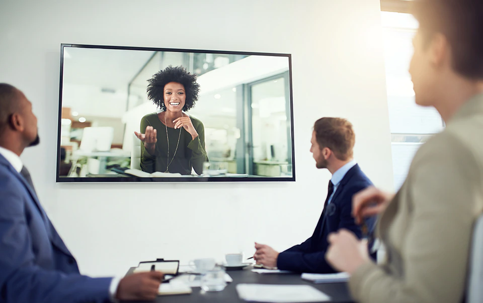 Woman meeting remotely with coworkers of tech company.