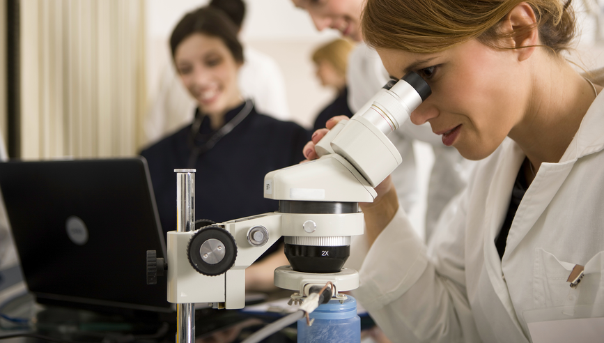 Female scientist using microscope