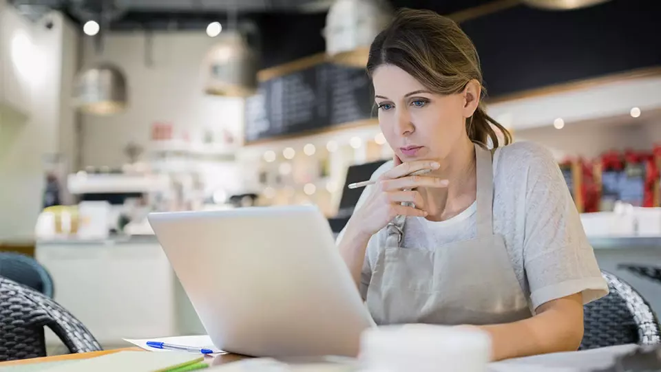 Woman reads on her laptop how to protect her business. 