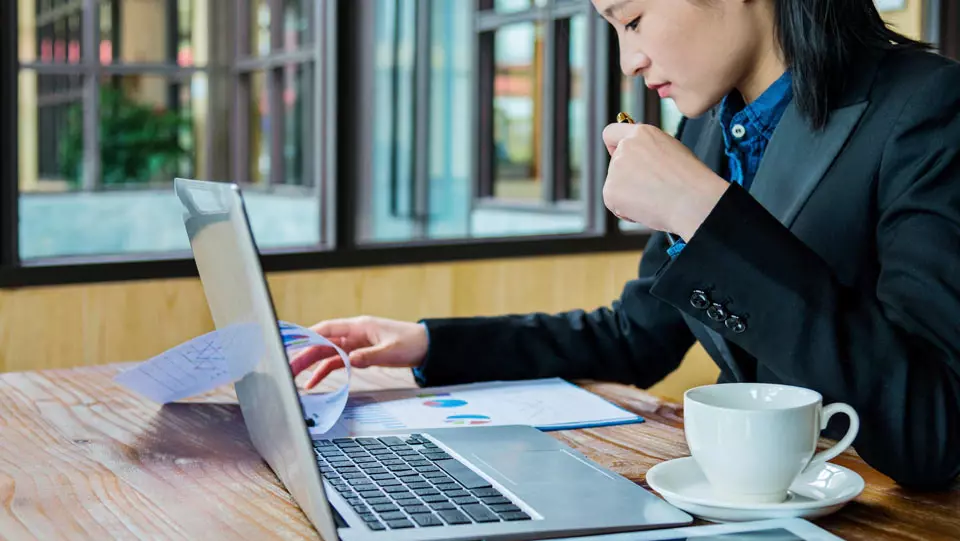 Woman road warrior working at a coffeeshop.