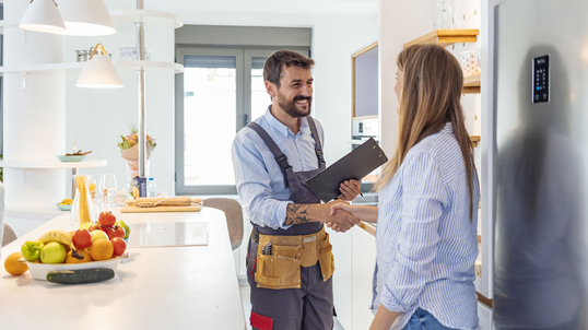 woman-shakes-hand-of-male-plumber-in-kitchen.jpg