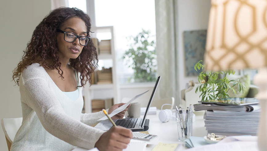 Woman sitting at computer in home office.