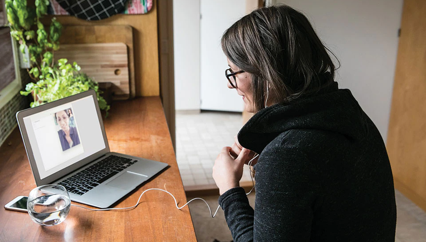 Woman sitting at desk having a video call.