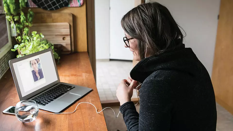 Woman sitting at desk having a video call.