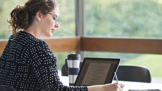 woman sitting at a desk working on a laptop computer.