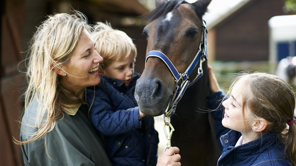 woman-with-son-daughter-petting-horse.jpg