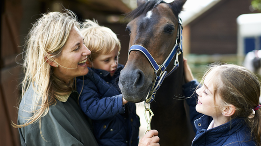 woman-with-son-daughter-petting-horse.jpg