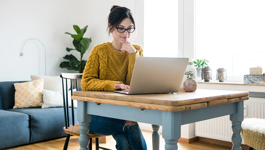 Woman working at her home desk on laptop.