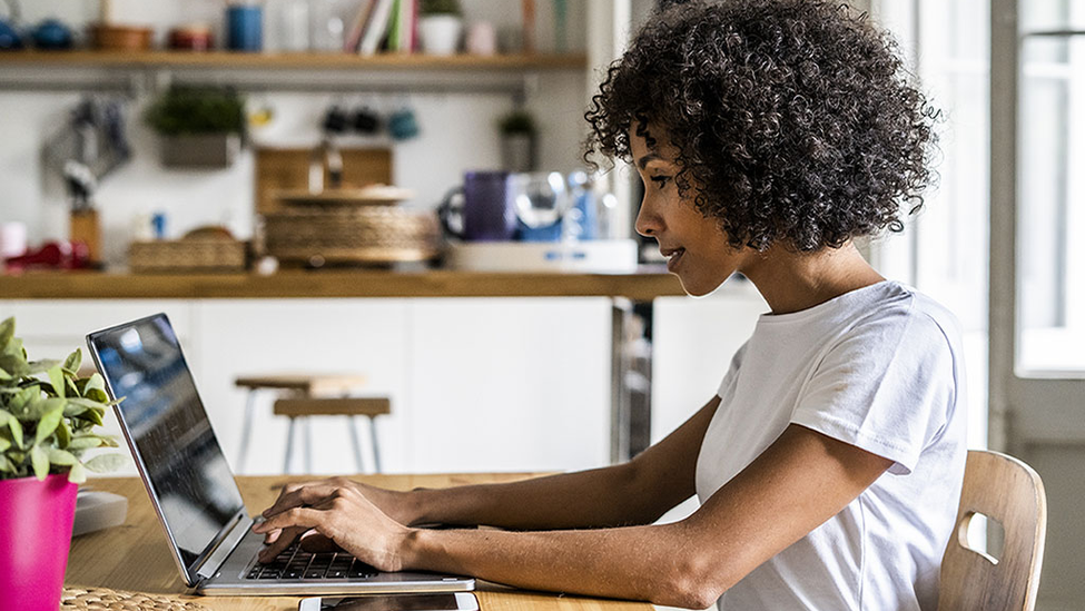 Woman working remotely from home on a laptop computer.