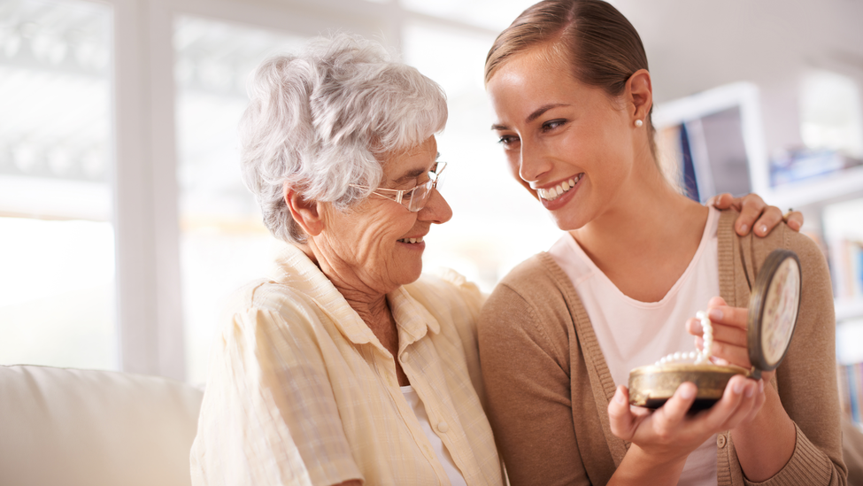 young woman showing older woman jewlery in a box.