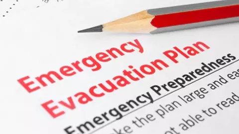 Writing an emergency evacuation plan on paper.