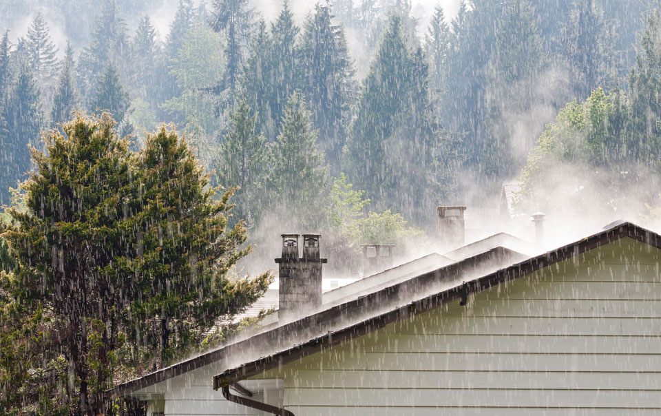 Heavy rain falling on roof of a house